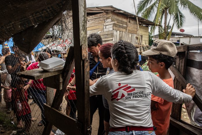 Mujer trabajadora de ONG Médicos Sin Fronteras asiste a grupo de personas en zona rural de Colombia en salud primaria y asistencia en violencia sexual.