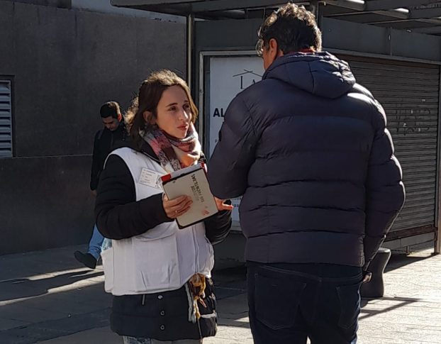 Trabajadora de Médicos Sin Fronteras hablando con un hombre en calle céntrica de Pergamino.