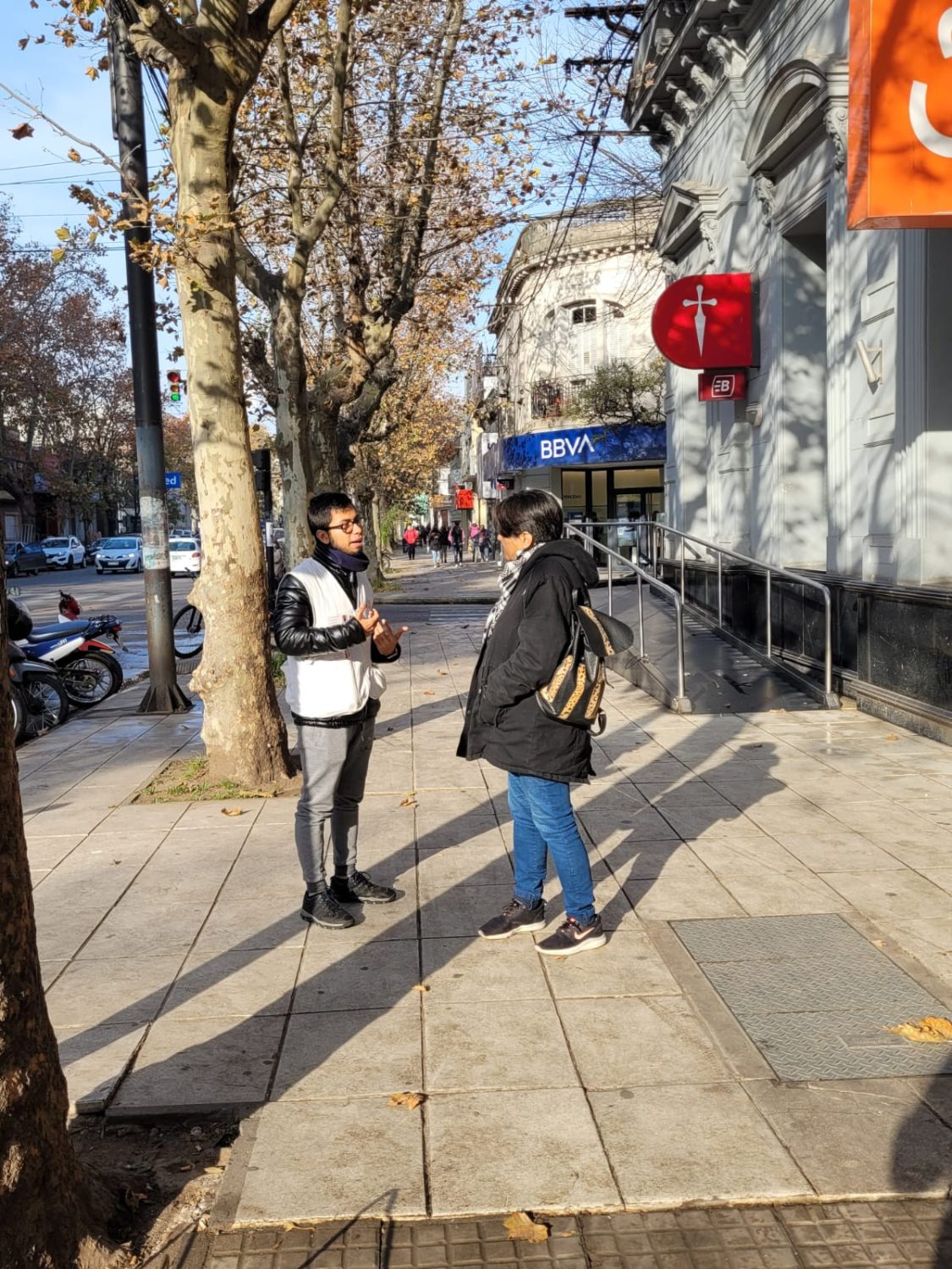 Joven de organización Médicos Sin Fronteras habla con una persona en una calle de la ciudad de Mercedes.