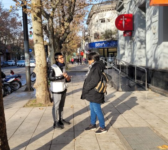 Joven de organización Médicos Sin Fronteras habla con una persona en una calle de la ciudad de Mercedes.