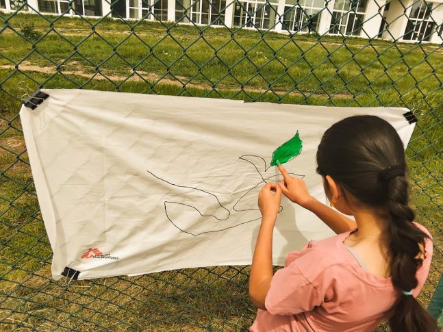 Niña pintando en una tela blanca en Bulgaria